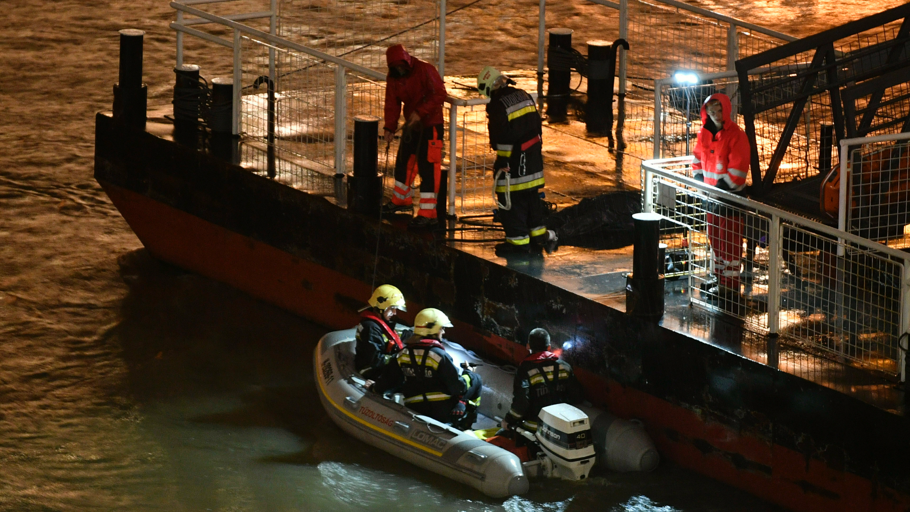 Responders sit in a rubber dinghy preparing for the search of victims next to a landing dock after a tourist boat crashed with another ship late Wednesday, May 29, 2019. , 2019, in Budapest, with dozens of people on board, including passengers and crew, Hungarian media reported. (Zsolt Szigetvary / MTI via AP)